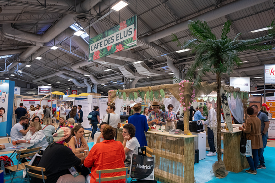 Vue du stand Café des élus avec des visiteurs assis à des tables