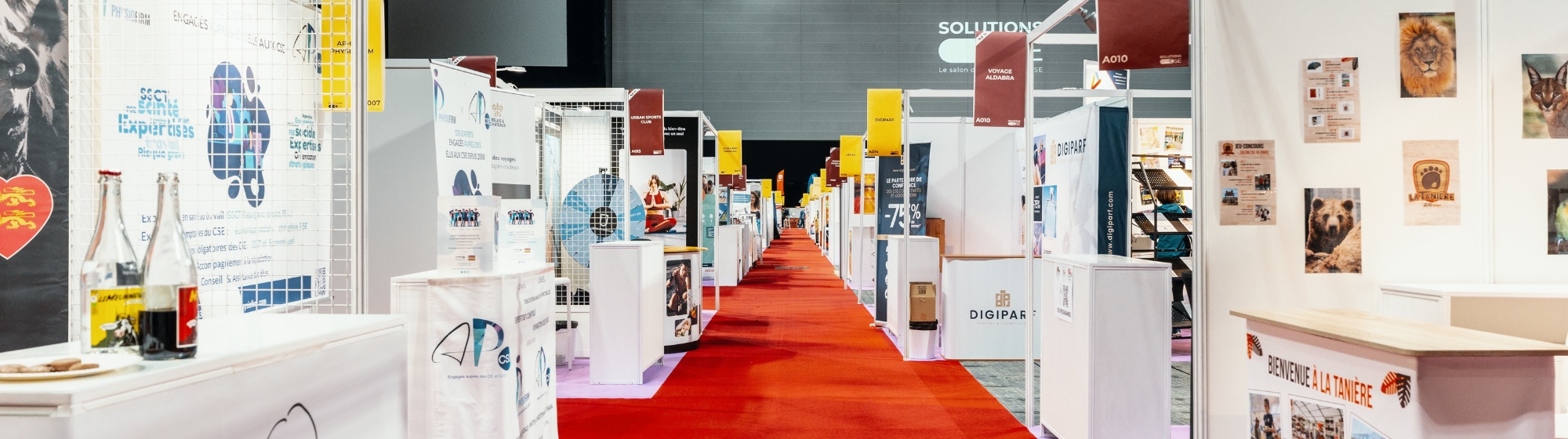 Un couloir avec un tapis rouge entouré de stands