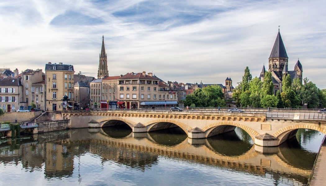 Vue de Metz avec ses bâtiments historiques et un pont sur la Moselle