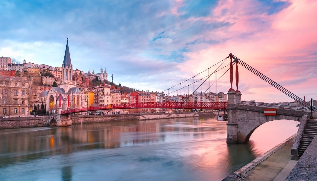Vue de Lyon avec un pont sur la Saône et la colline de Fourvière au coucher du soleil