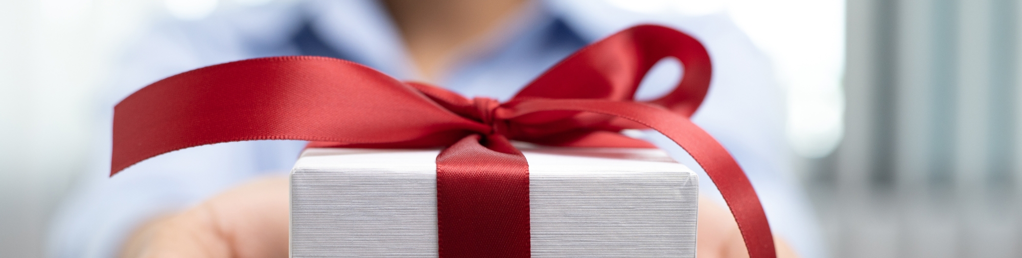Cadeau emballé avec un ruban rouge illustrant les avantages et attentions proposés par les CSE