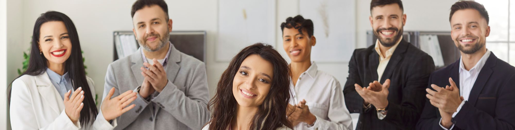 Une équipe mobilisée autour d’un projet commun Équipe de professionnels applaudissant une collaboratrice dans un environnement de travail
