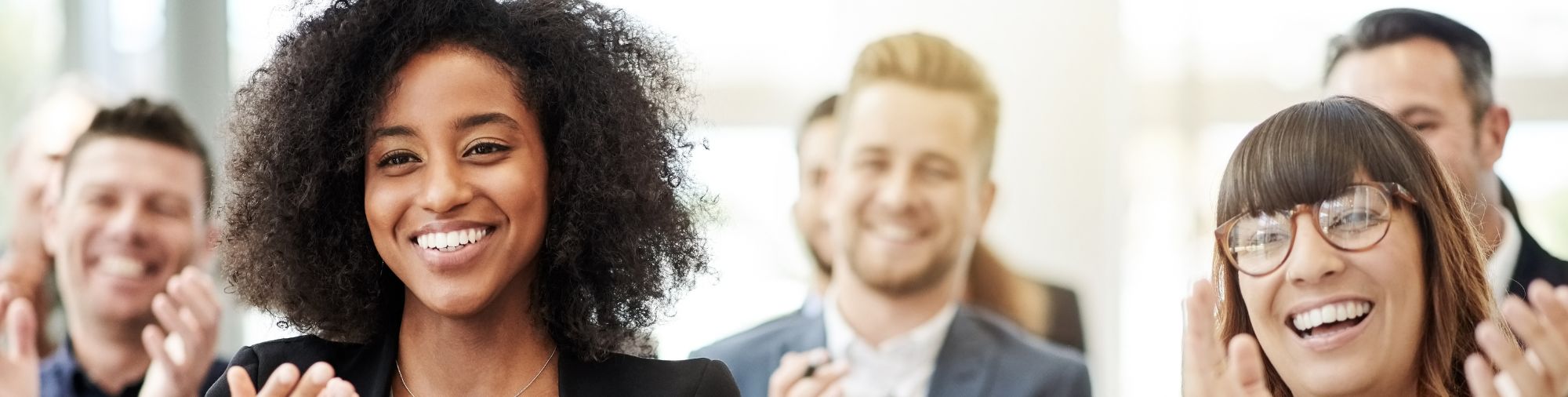 Groupe de collaborateurs souriants applaudissant ensemble