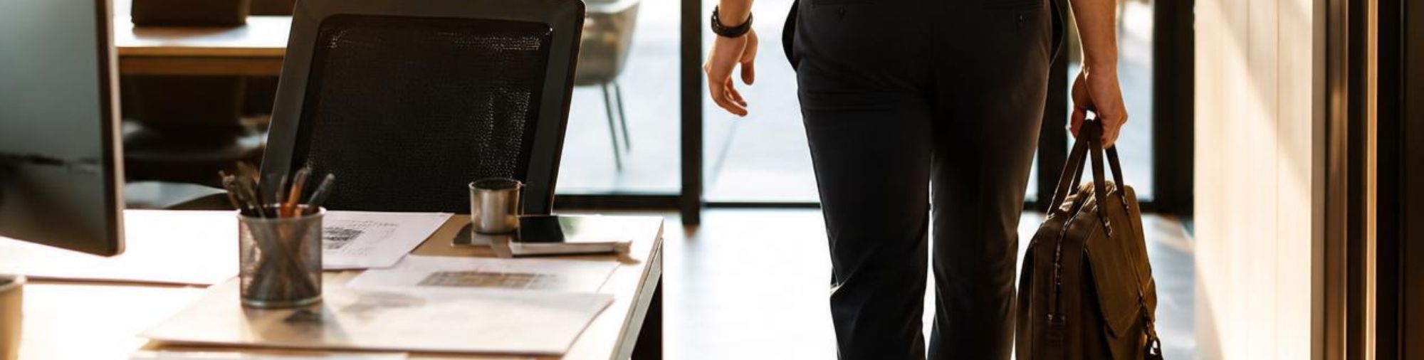 Homme quittant son bureau avec son sac, vu de dos, symbolisant l’abandon de poste