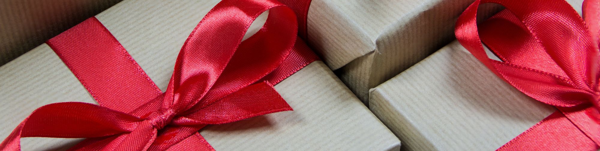 cadeaux-cse-rubans-rouges-coffrets Gros plan sur des coffrets cadeaux CSE décorés avec des rubans rouges