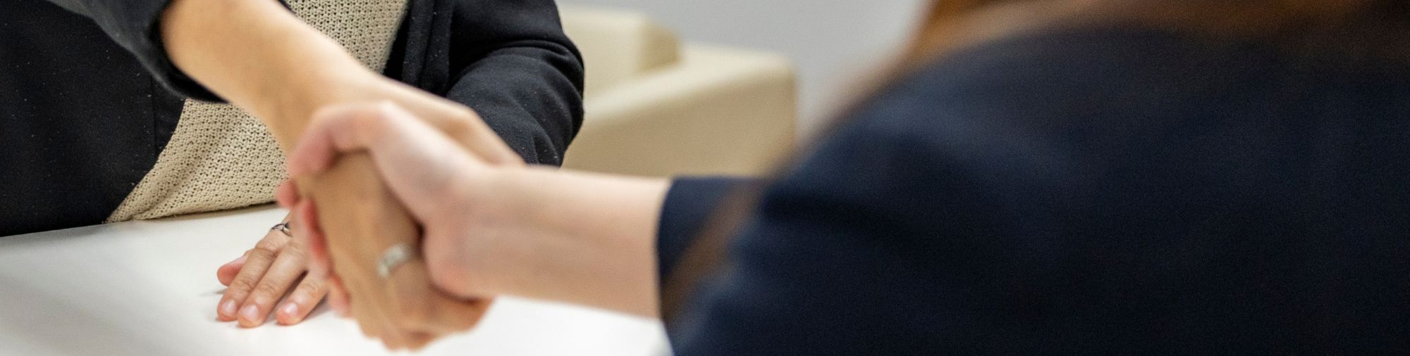 Deux femmes se serrant la main autour d'une table