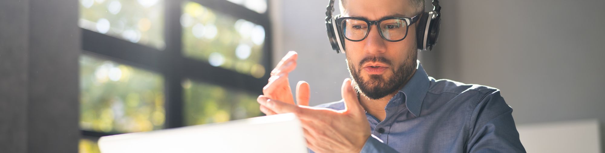 Webinaire SolutionsCSE x Urssaf Homme participant à un webinaire en ligne avec un casque devant son ordinateur