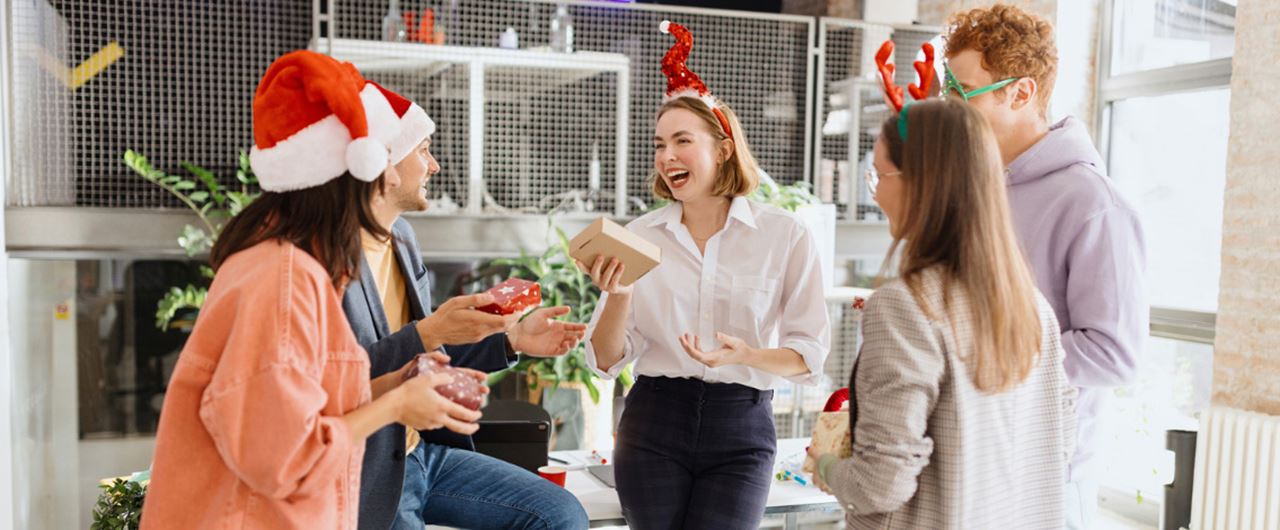 Groupe de personnes souriant et portant un bonnet de Noël