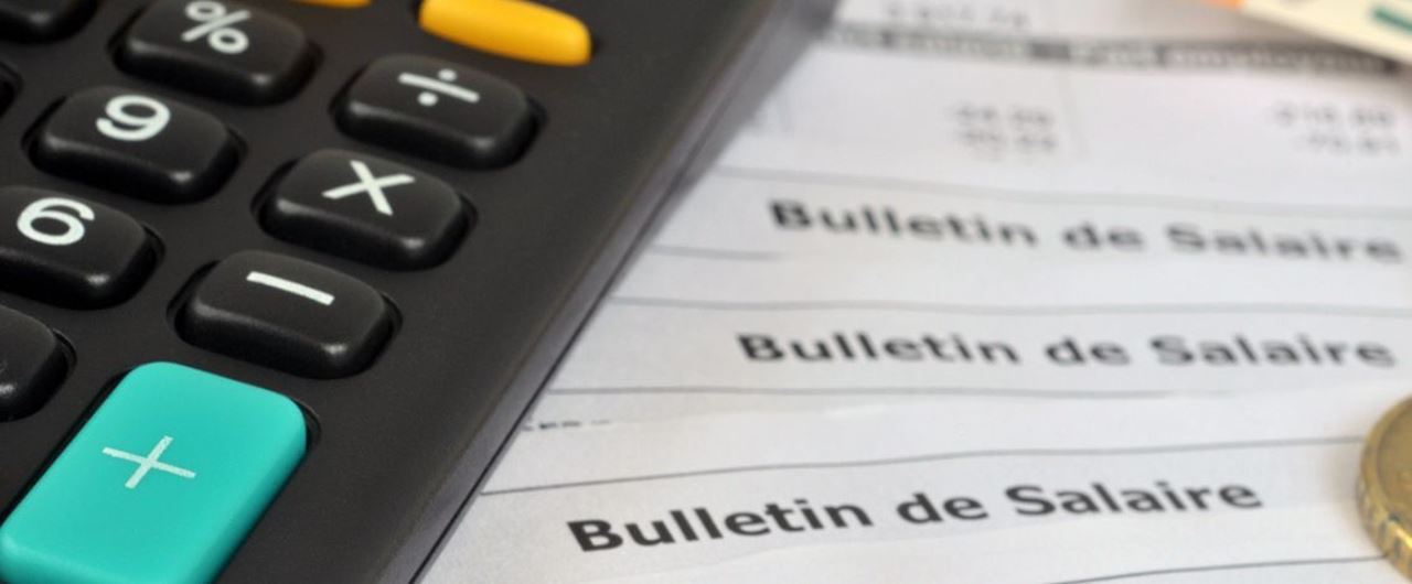 Calculatrice posée sur des bulletins de salaire