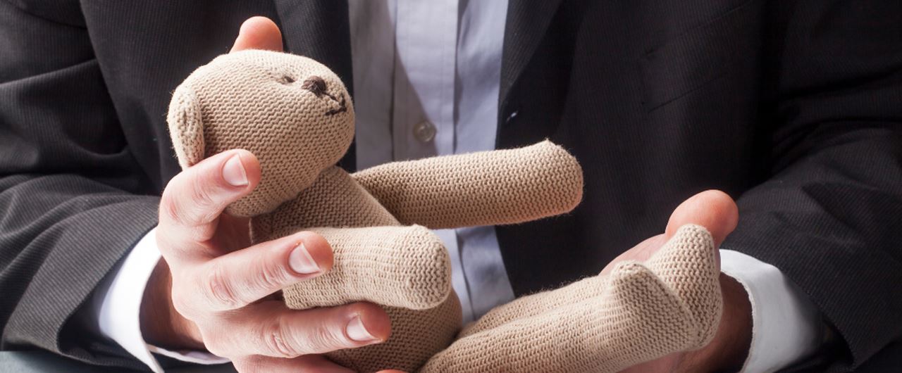 Un homme tient une peluche dans ses mains