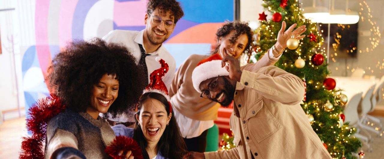 Un groupe de personnes souriant devant un arbre de Noël