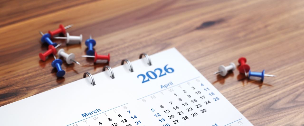 Calendrier et punaises posés sur une table
