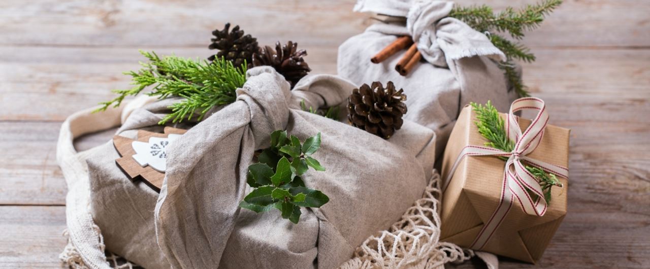 Plusieurs cadeaux emballés avec des pommes de pins et des branches de sapin