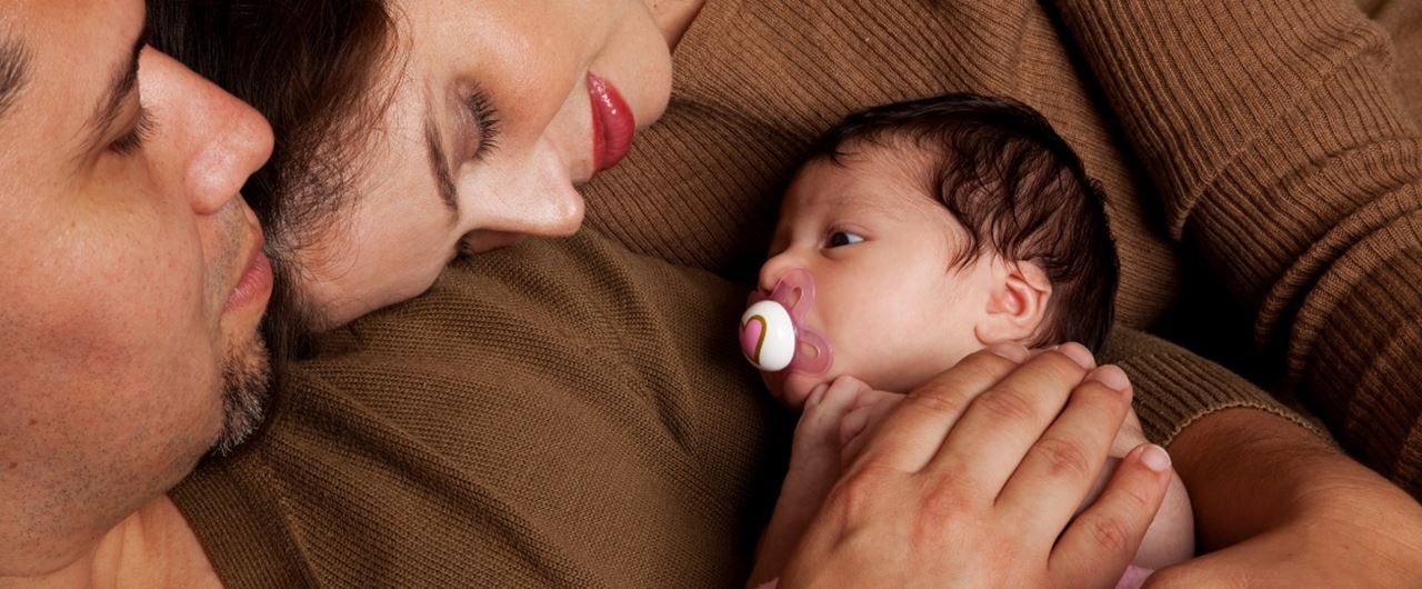 Un homme et une femme tenant un bébé
