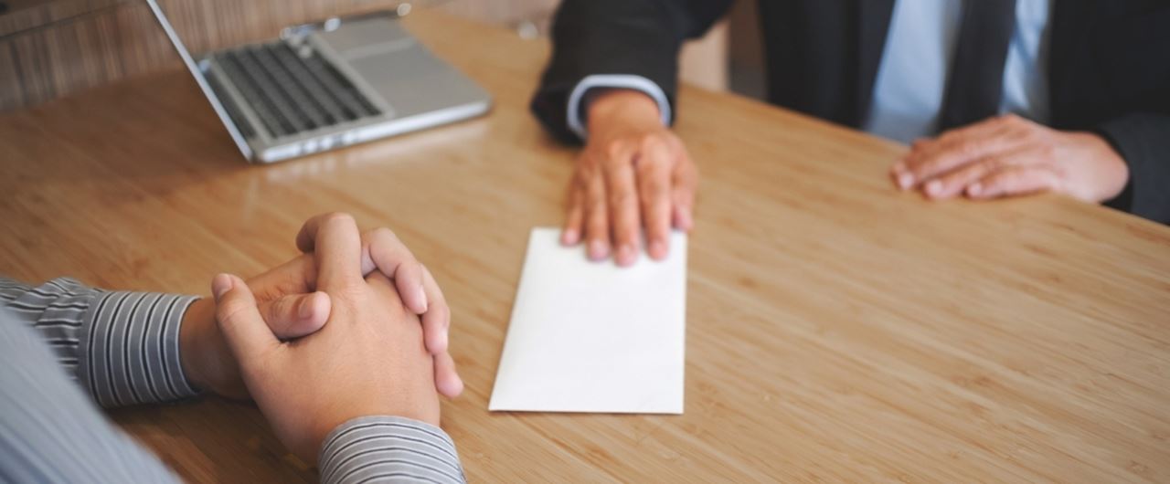 Un homme posant sa main sur une enveloppe blanche