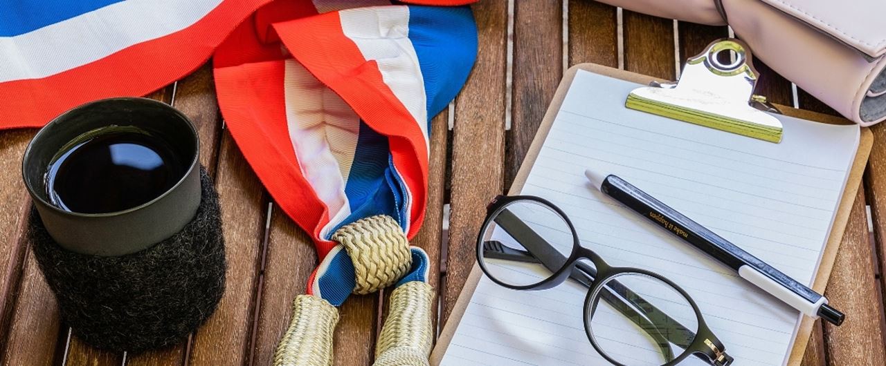 Une écharpe d'élu français avec un cahier et des lunettes