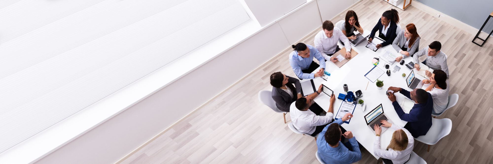 12 personnes assises autour d'une table de travail