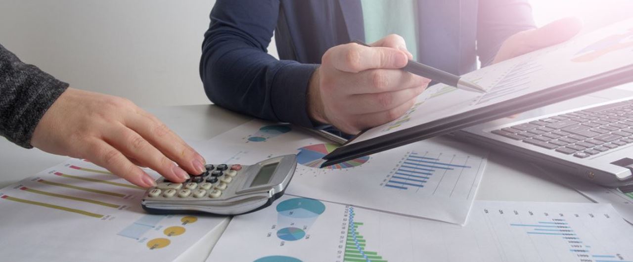 Un homme avec une calculatrice et un dossier avec des graphiques