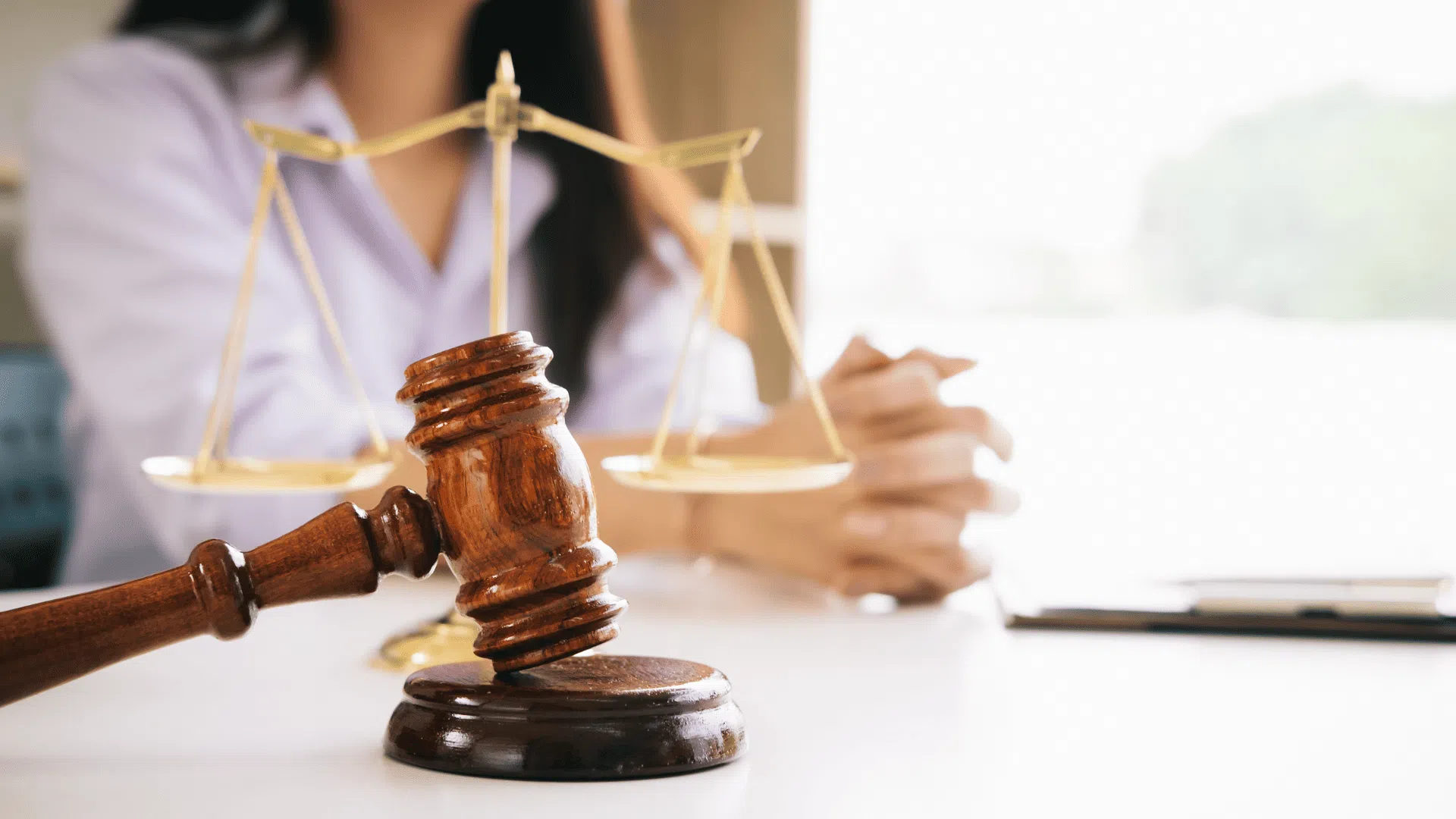 Une balance de justice sur une table avec une femme derrière
