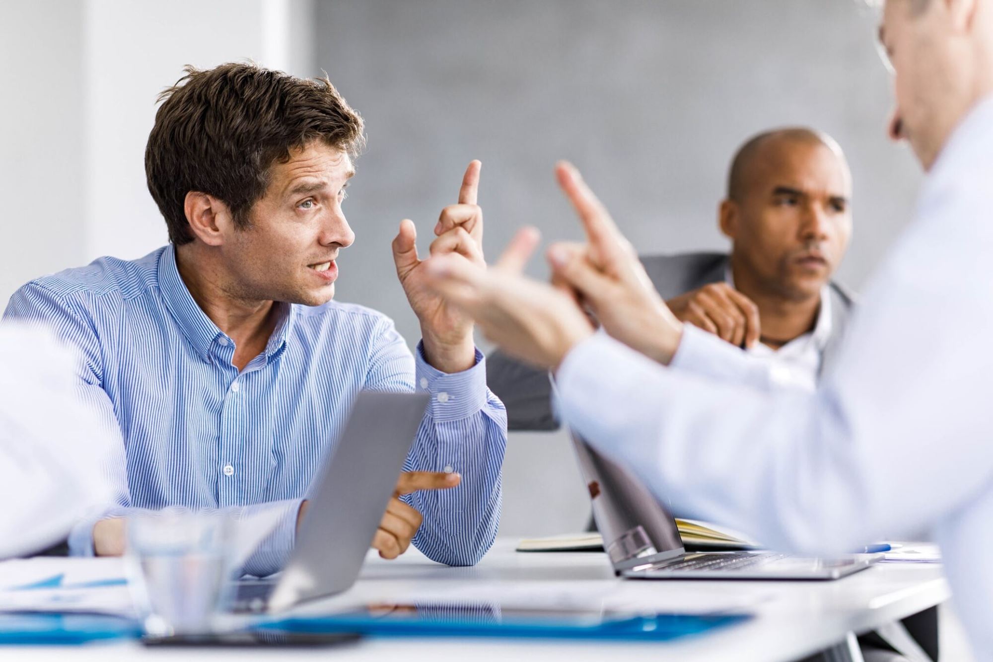 Trois hommes discutant vivement