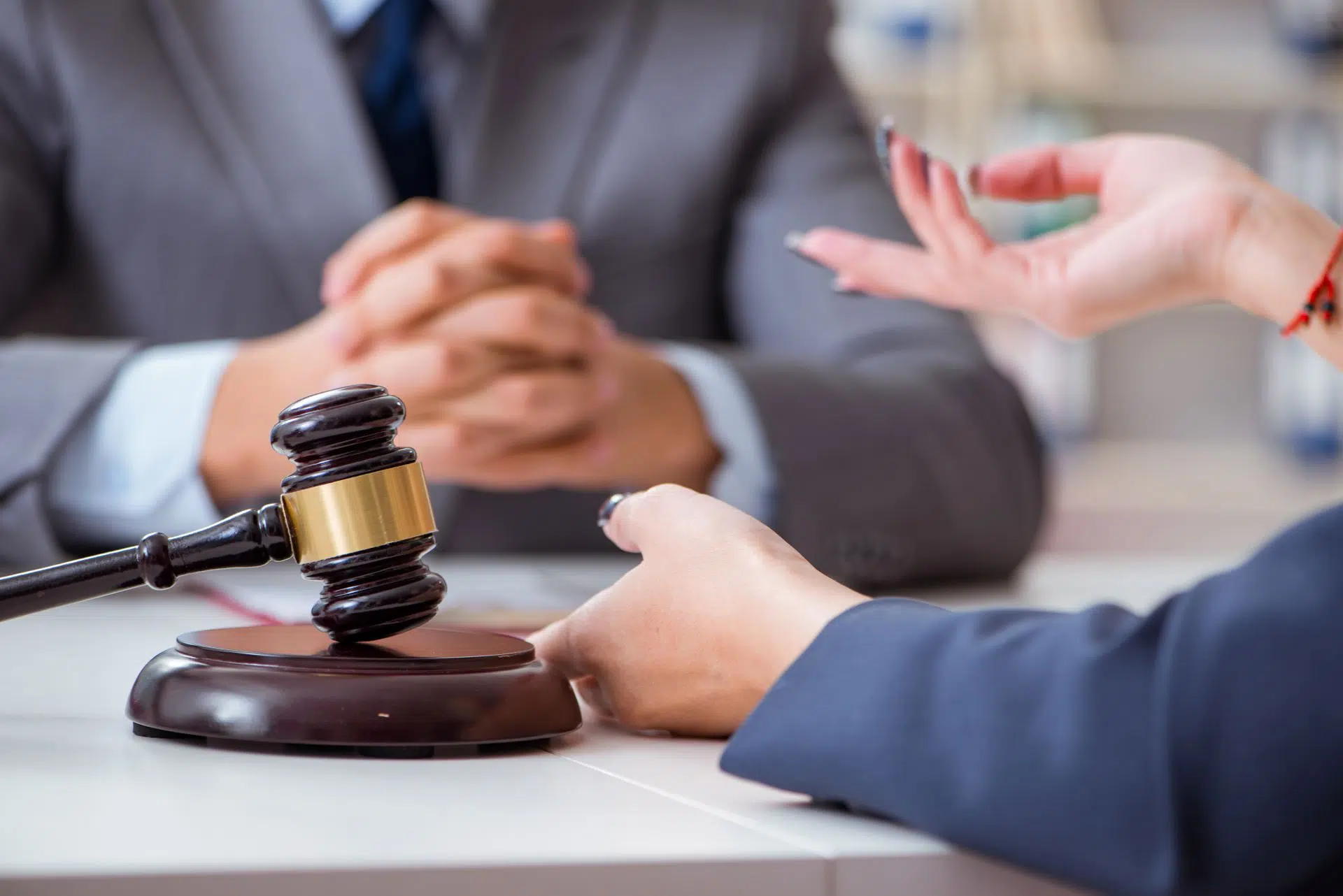 Un marteau de juge sur un table entre deux personnes