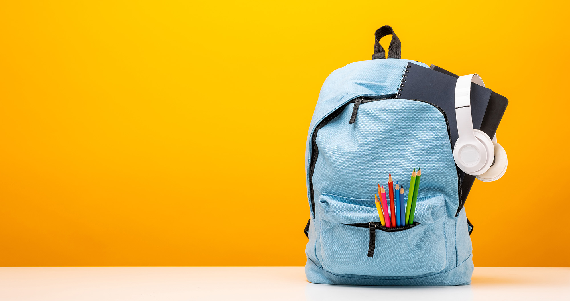 Un sac à dos rempli sur une table avec un fond jaune