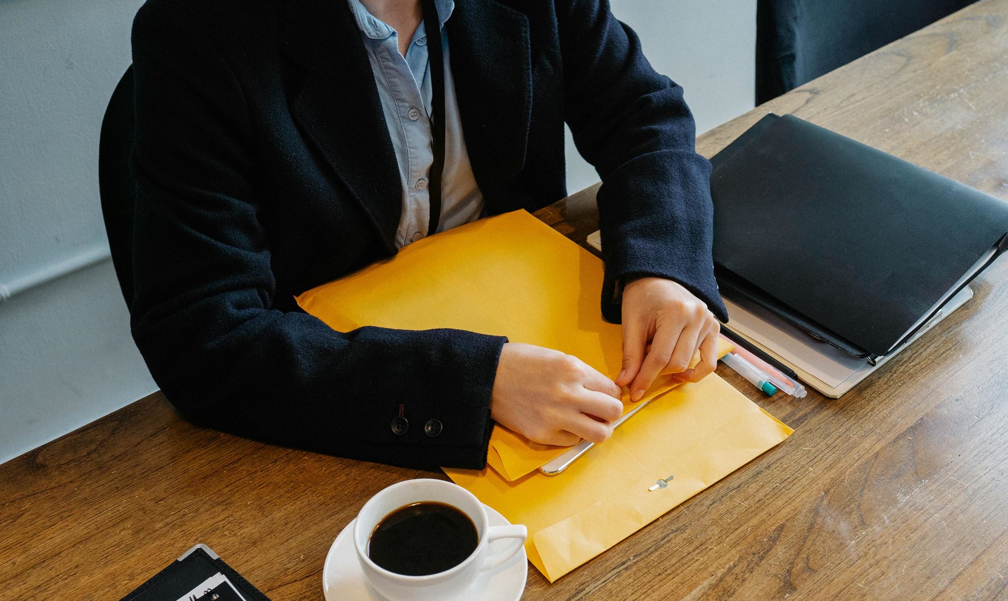 Un homme assis une table avec un dossier jaune devant lui