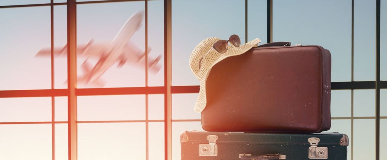 Plusieurs valises dans un aéroport avec un avion derrière