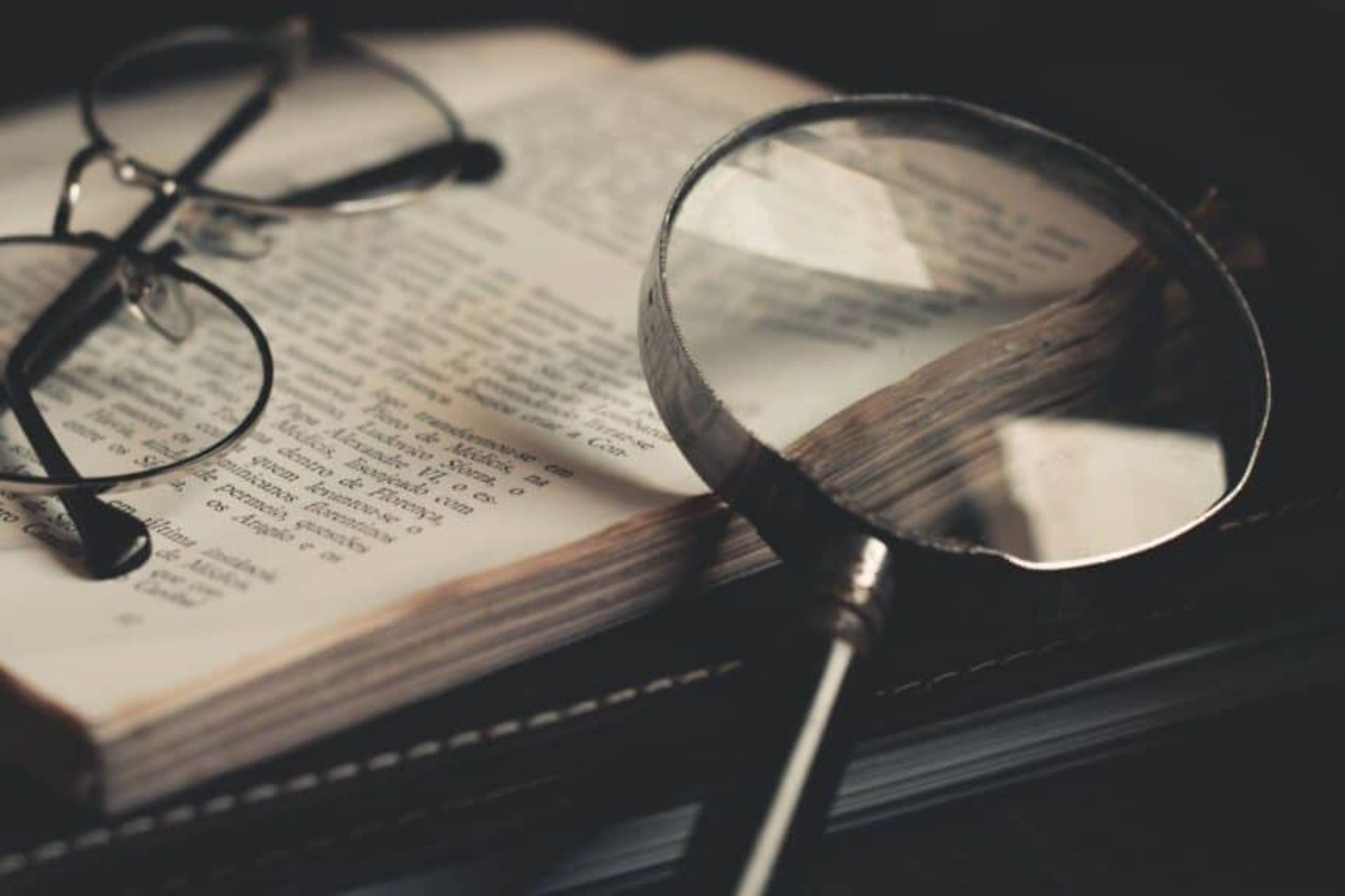 Une loupe et des lunettes posées sur un livre