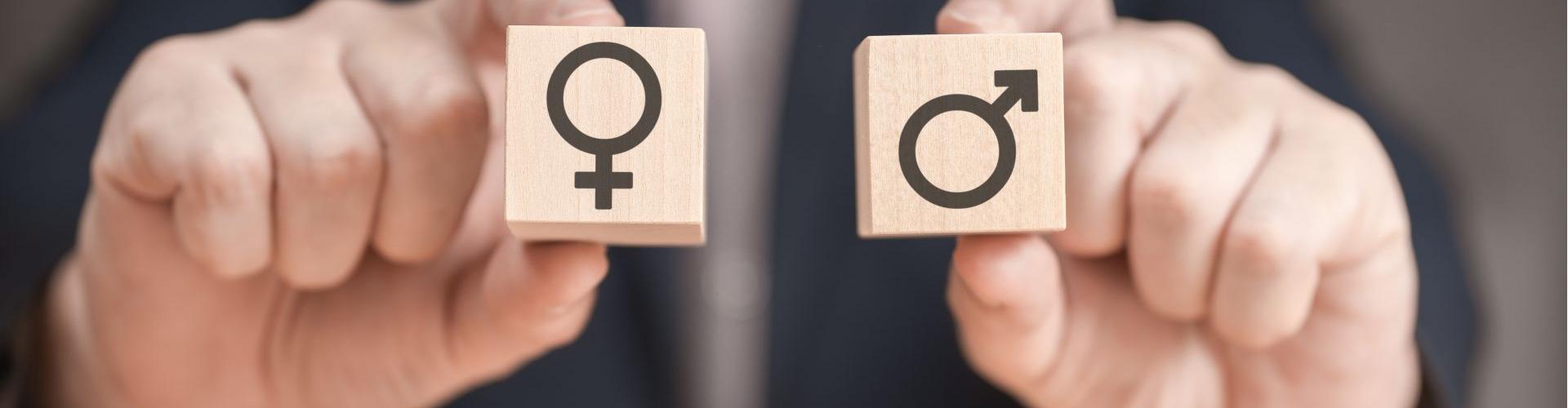 Deux dés en bois avec les symboles masculins et féminins