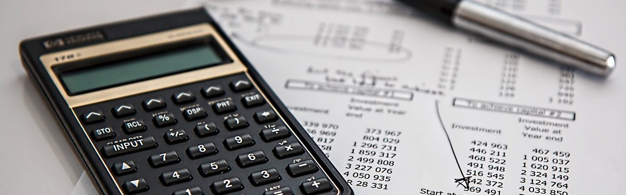 Une feuille de paie avec une calculatrice et un stylo