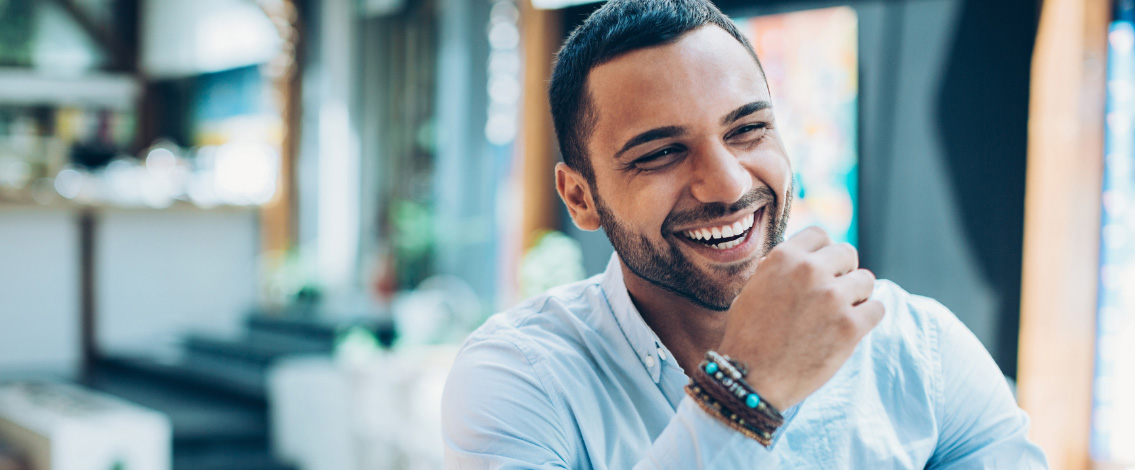 Un homme souriant avec un bracelet au poignet