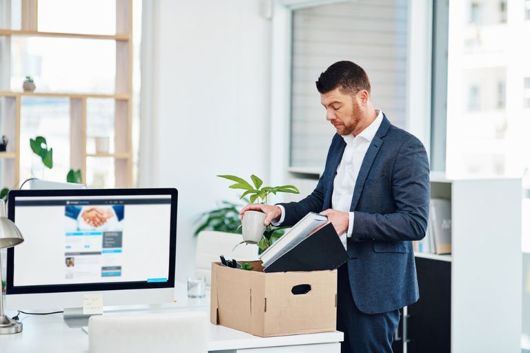Un homme rangeant des affaires dans un carton