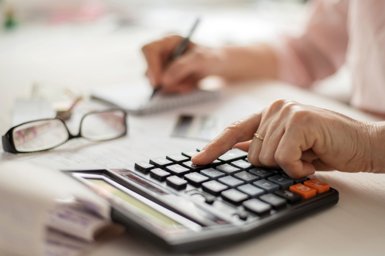 Une calculatrice avec des lunettes sur un bureau