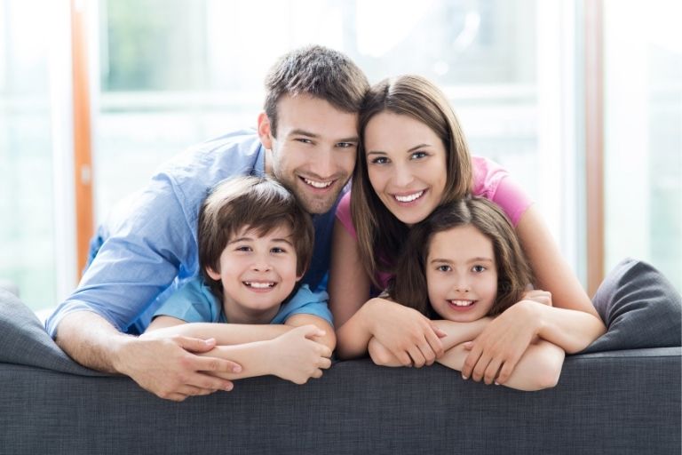 Un homme, une femme, un petit garçon et une petite fille sur un canapé