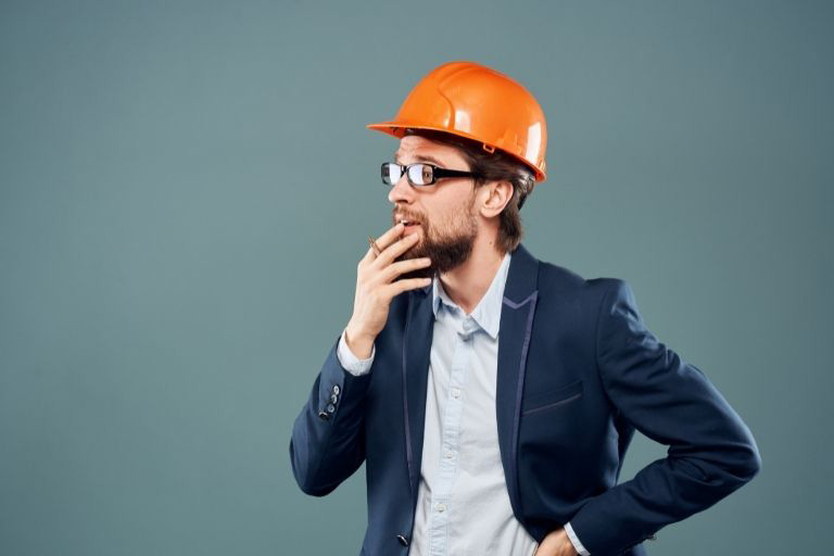 Un homme en costume portant un casque de chantier orange