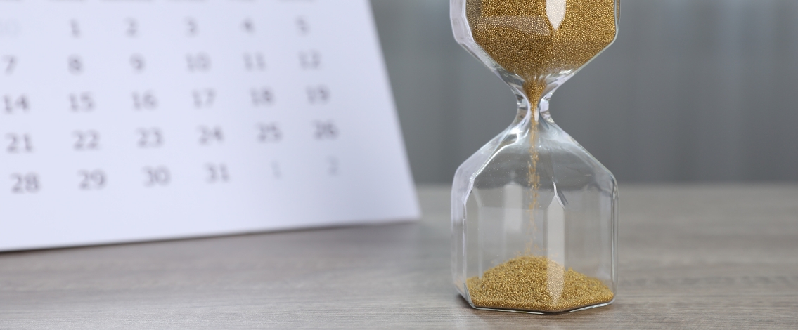 Un sablier avec un calendrier derrière