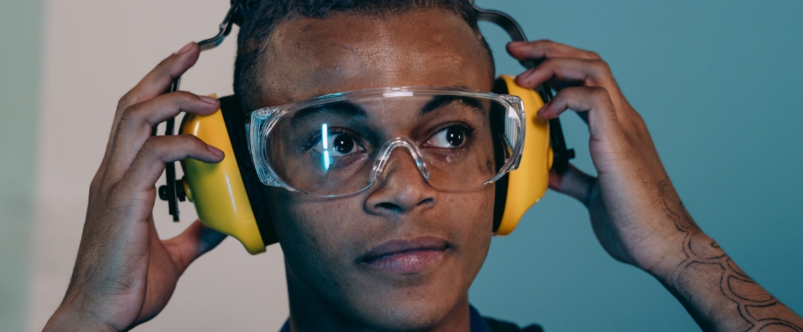 Un homme portant des lunettes de protection et un casque anti-bruit