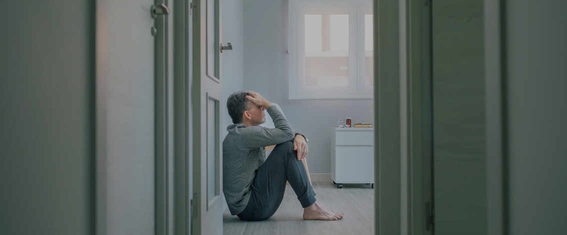 Un homme assis par terre dans une chambre