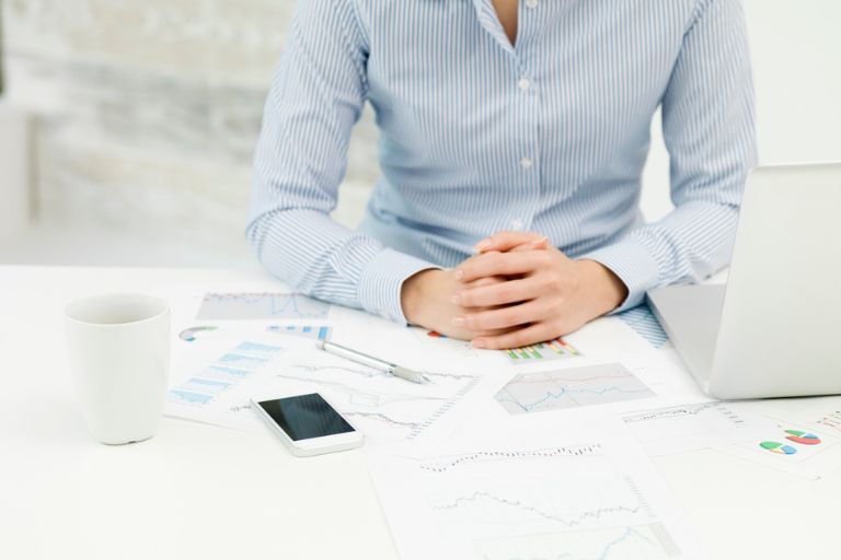 Un employé à son bureau les mains croisées