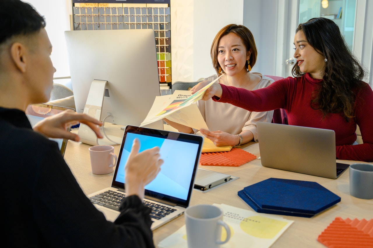 Trois personnes discutant autour de graphiques