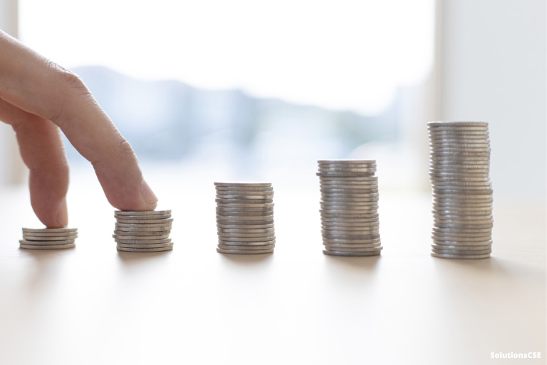 Une main gravissant des piles de monnaie