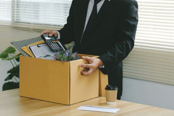 Un employé part avec ses affaire dans un carton