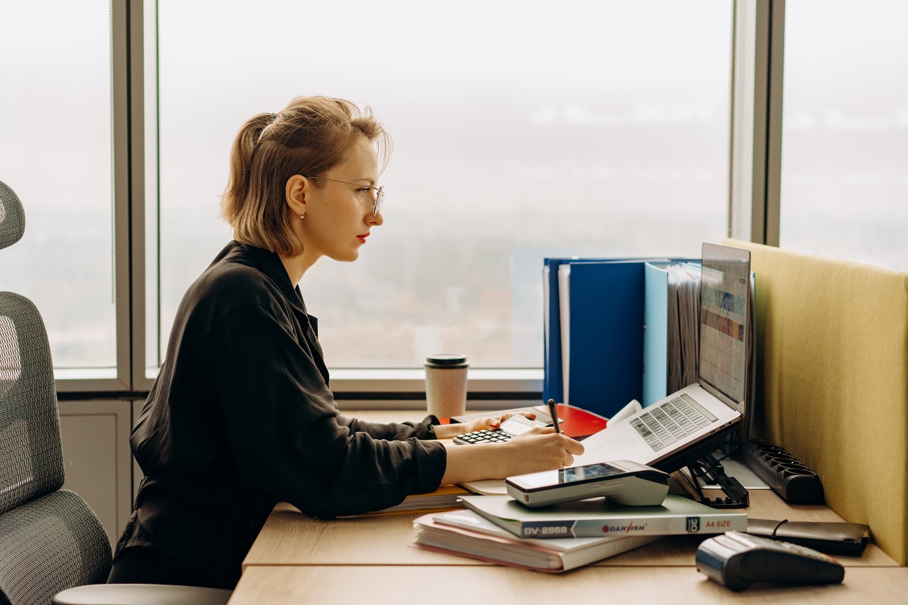 Une femme de profil devant un ordinateur