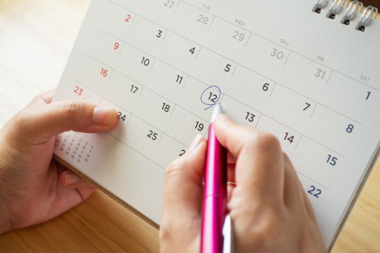 Une personne écrivant sur un agenda