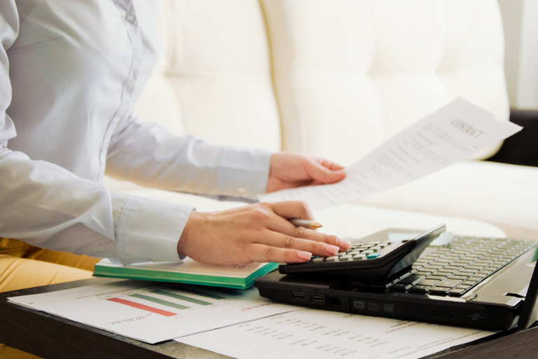 Une personne utilisant une calculatrice pour remplir un document