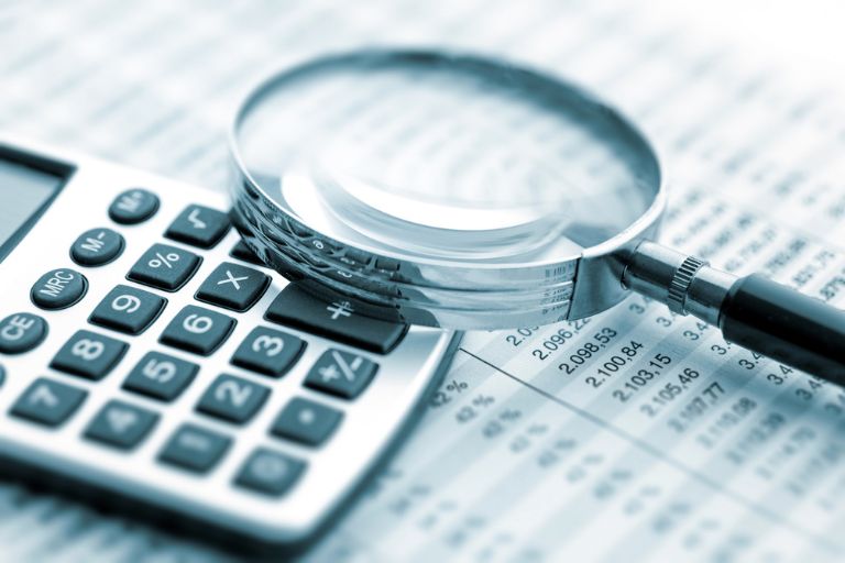 Une loupe posée sur une calculatrice