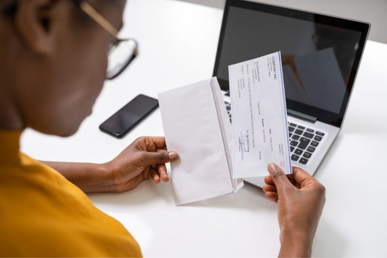 Une femme sortant un document d'une enveloppe