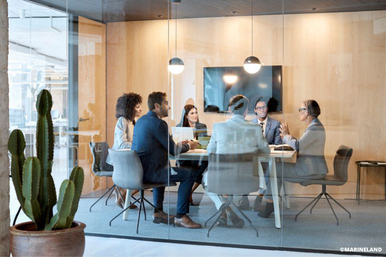 Une salle de réunion vitrée avec des employés