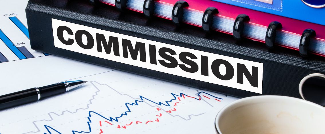 commission-folder-charts Dossier marqué COMMISSION posé sur documents financiers avec graphiques et stylo